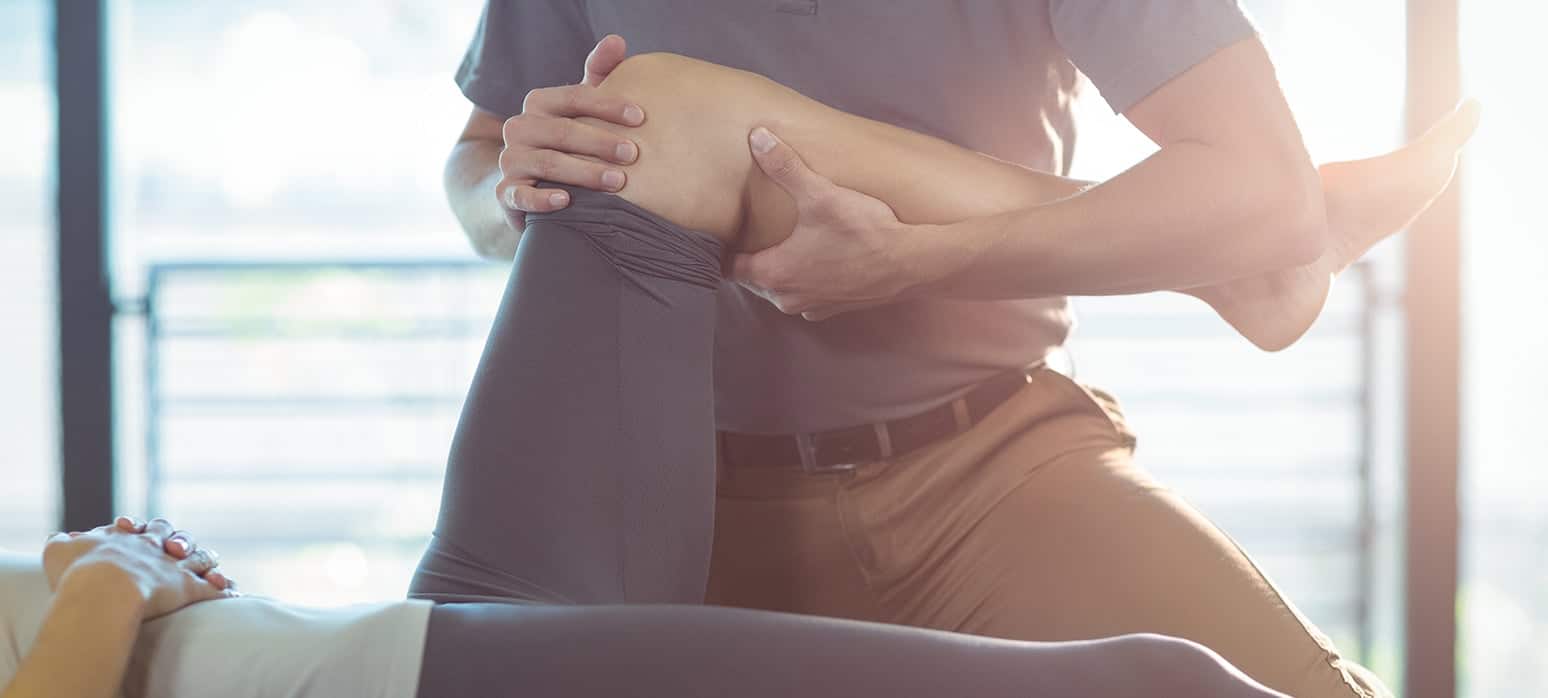 A physical therapist doing exersises on a womans knee